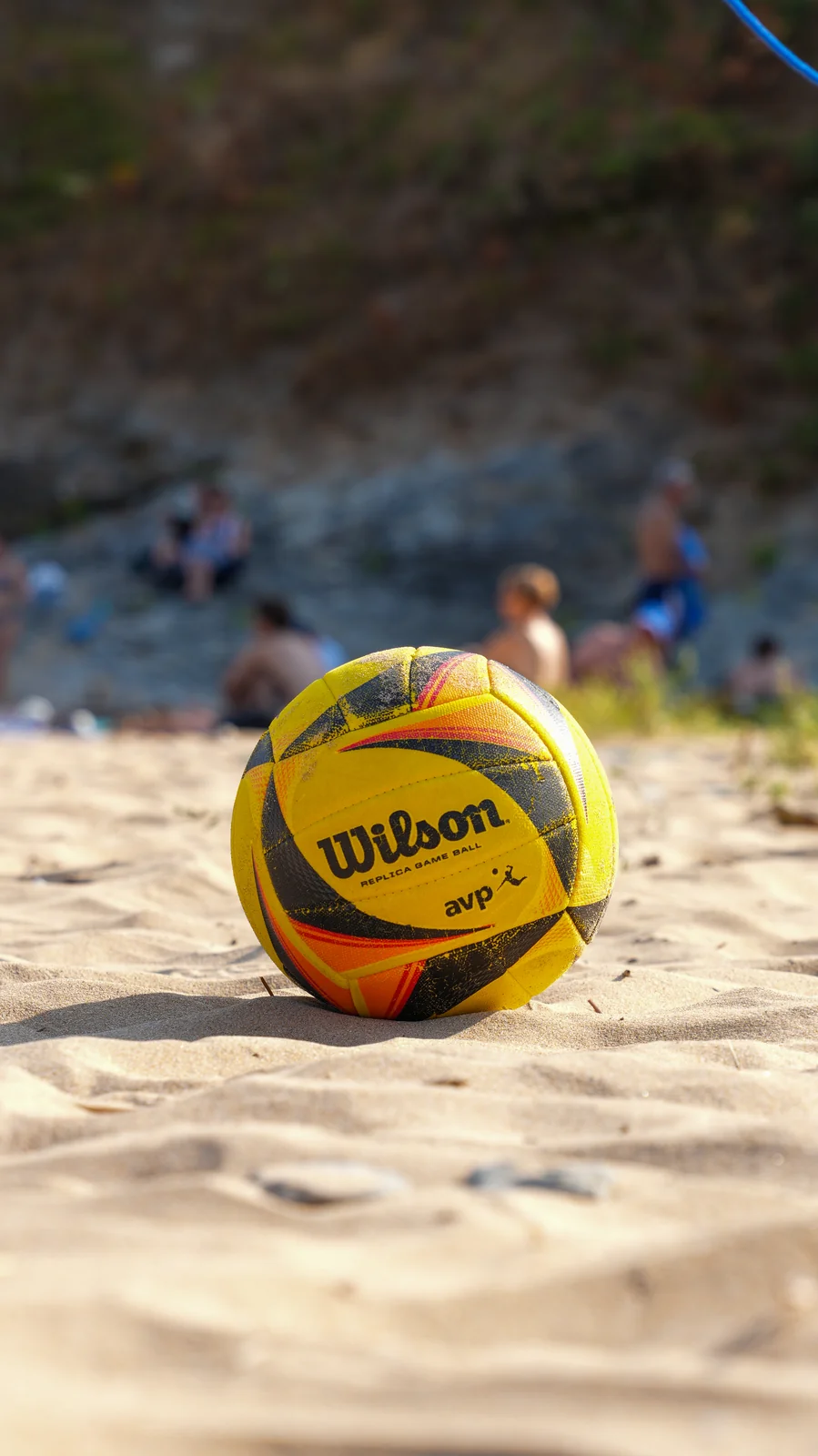 Ballon de beach-volley dans le sable, plage en arrière-plan flou