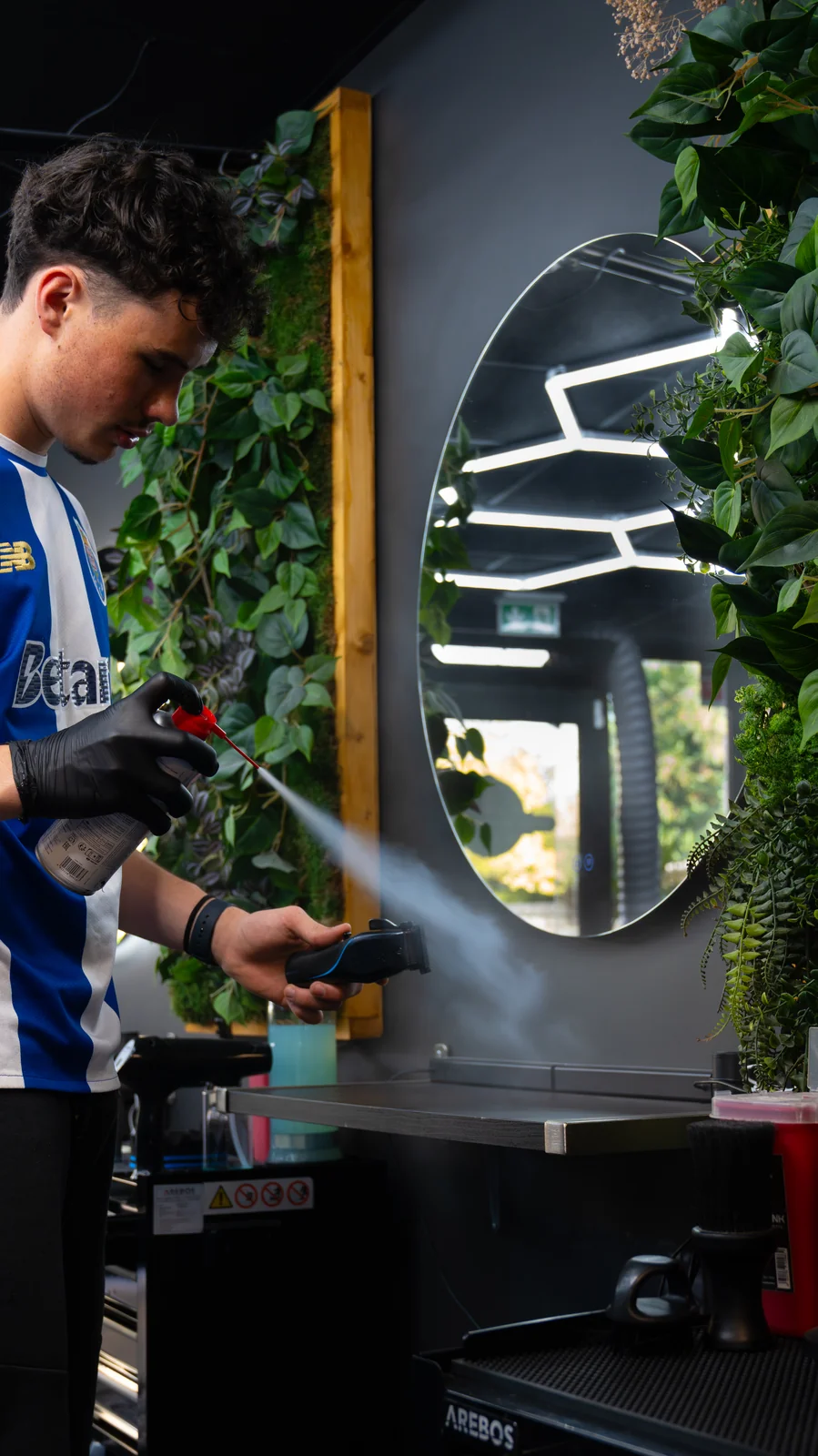 Barbier vaporisant la coupe devant le miroir