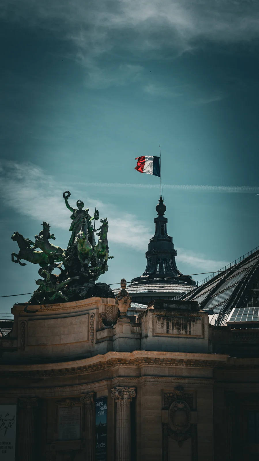 Sculpture équestre et drapeau français sur un toit parisien