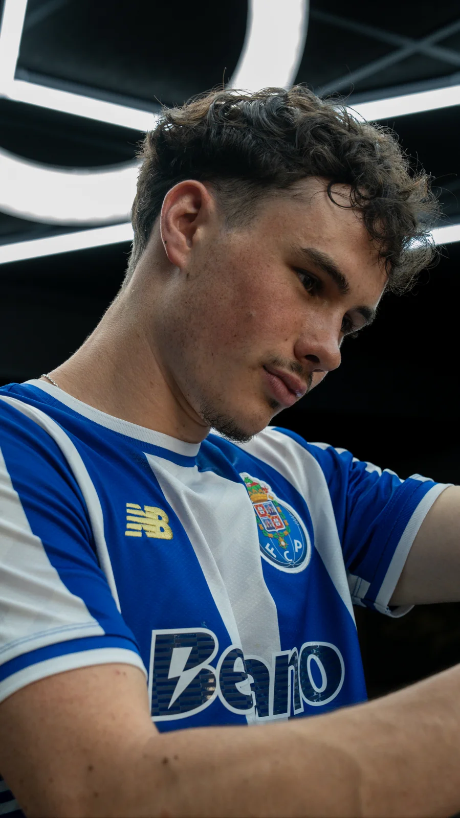 Barbier en maillot bleu et blanc, concentré sur sa coupe